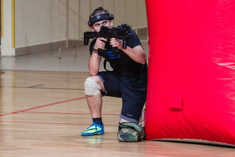 Боец LASERWAR в низком прицеле за красным укрытием.